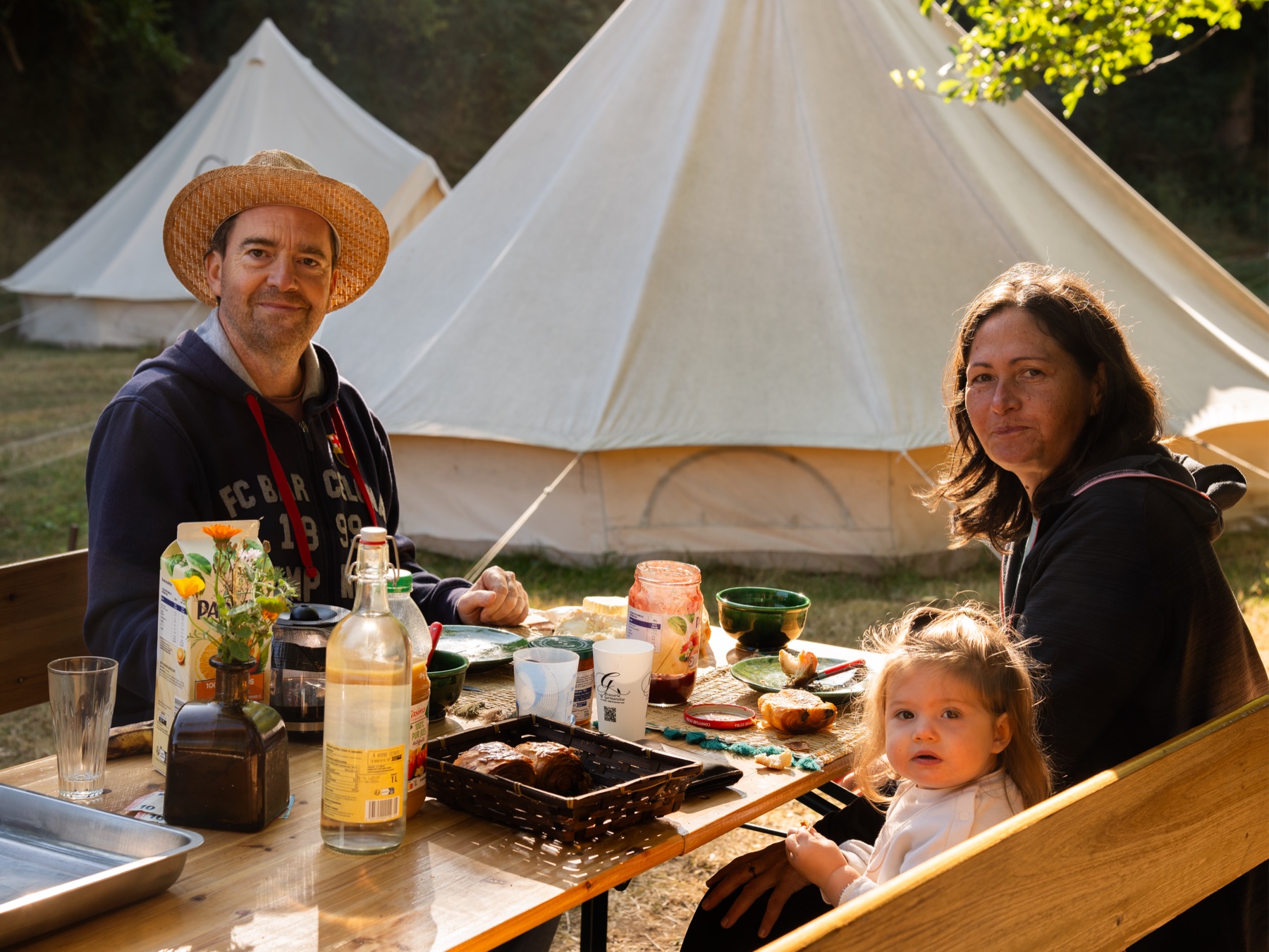 Une famille partage un petit déjeuner devant les tentes du campement